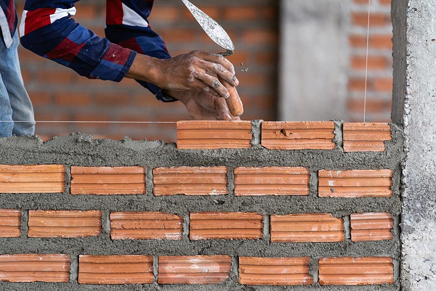 person-building-brick-wall